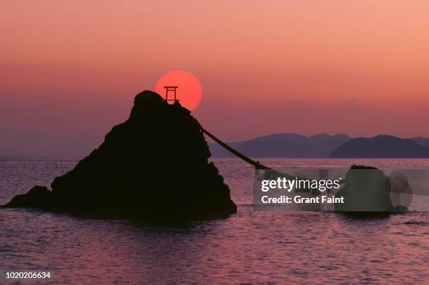 two rock formations at sunrise . - shintoismus stock-fotos und bilder