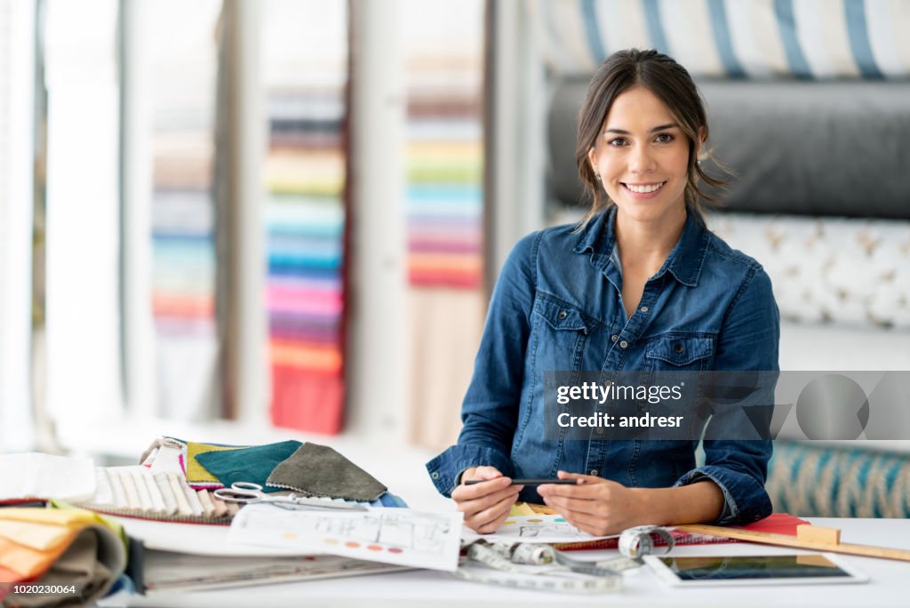 Interior designer working at her workshop choosing fabrics