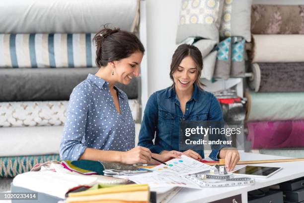 innenarchitekten wahl stoffe auf ein textilgeschäft und im gespräch mit der verkäuferin - stoffmuster stock-fotos und bilder