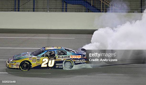 Joey Logano, driver of the GameStop Toyota, performs a burnout to celebrate after winning the NASCAR Nationwide Series Meijer 300 presented by Ritz...