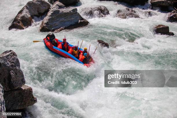 Small group of men and women white water river rafting