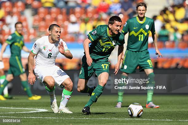 Medhi Lacen of Algeria chases Andraz Kirm of Slovenia during the 2010 FIFA World Cup South Africa Group C match between Algeria and Slovenia at the...