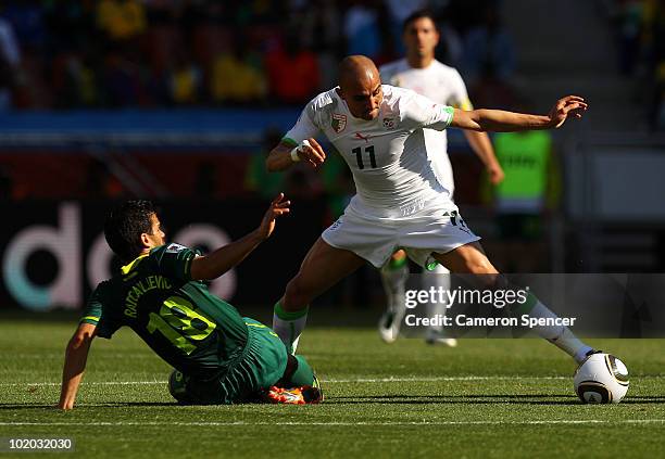 Rafik Djebbour of Algeria is tackled by Aleksandar Radosavljevic of Slovenia during the 2010 FIFA World Cup South Africa Group C match between...