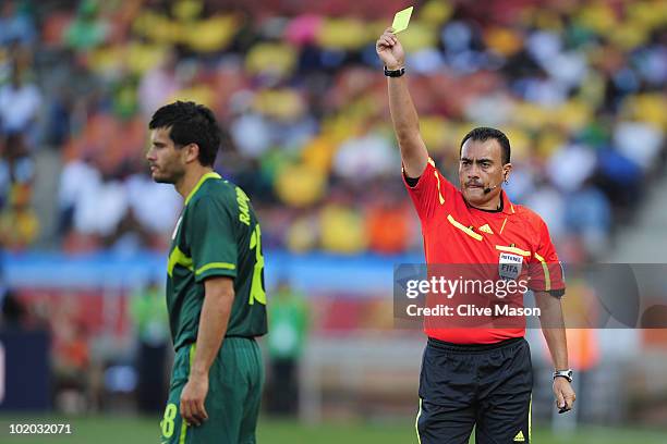 Aleksandar Radosavljevic of Slovenia receives a yellow card from referee Carlos Batres during of the 2010 FIFA World Cup South Africa Group C match...