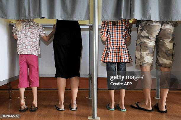 Parents come with their kids to vote at polling stations, during the Federal Election Day, on June 13 in Brakel. Belgian voters went to the polls for...