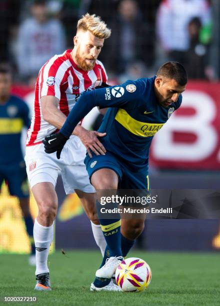 Ramon Abila of Boca Juniors fights for the ball with Jonatan Schunke of Estudiantes during a match between Estudiantes and Boca Juniors as part of...