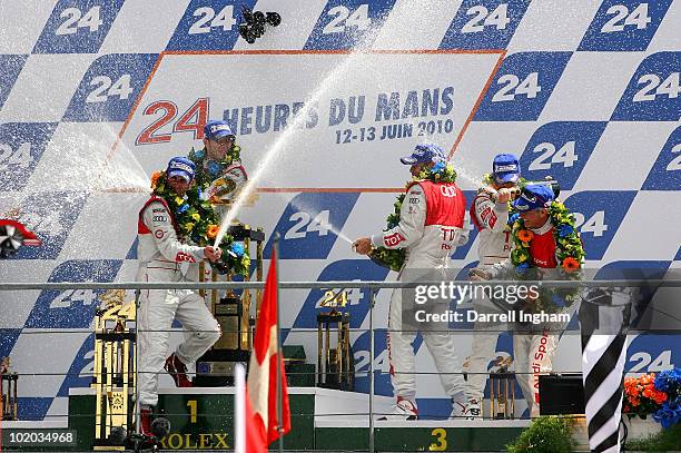 Romain Dumas of France and Timo Bernhard of Germany, co drivers of the Audi Sport North America Audi R15 are showered with champagne by team mates...