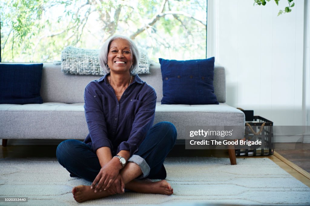 Portrait of senior woman sitting on floor at home