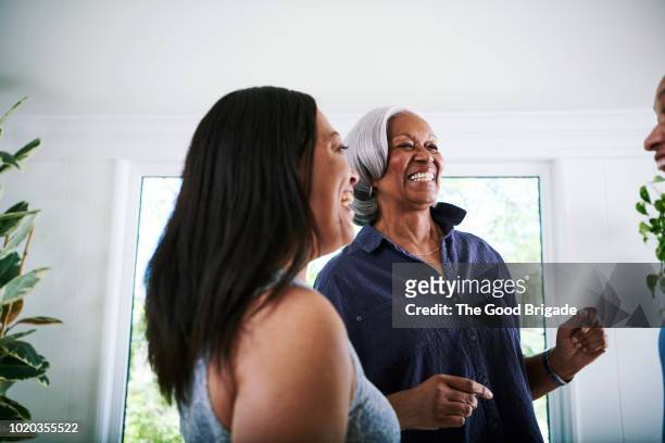 Mother and daughter dancing in living room at home