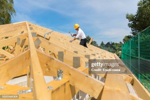 industria edile - carpentiere roofer che lavora sul tetto - costruttore di tetti foto e immagini stock