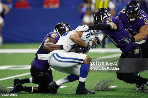 Albert McClellan and Kai Nacua of the Baltimore Ravens make a tackle against Ross Travis of the Indianapolis Colts in the third quarter of a...