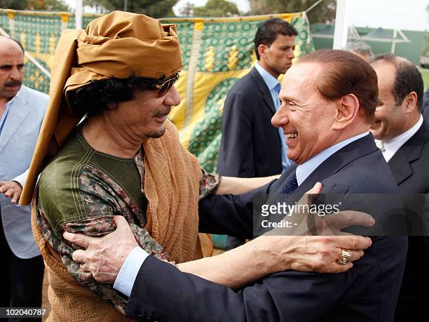 Libyan leader Moamer Kadhafi welcomes Italian Prime Minister Silvio Berlusconi upon arrival for a meeting along with other European premiers and...