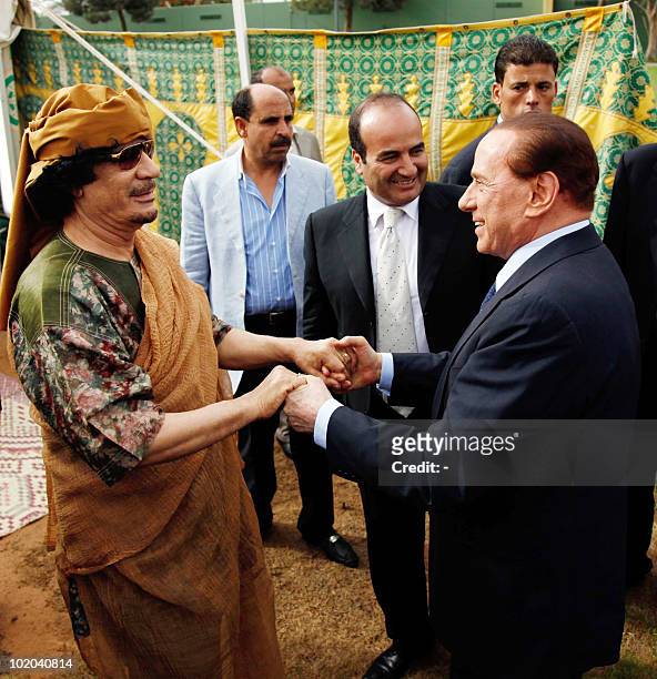 Libyan leader Moamer Kadhafi welcomes Italian Prime Minister Silvio Berlusconi upon arrival for a meeting along with other European premiers and...