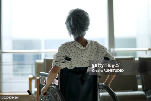 senior patient sitting on wheelchair in hospital - 老人ホーム ストックフォトと画像