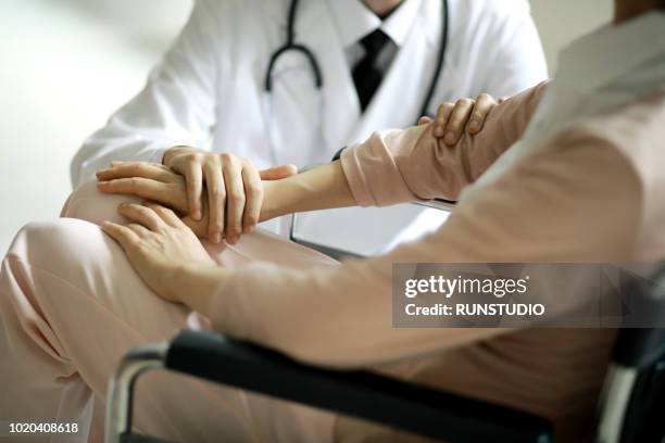 close up of doctor assisting  senior woman in wheelchair - elderly care japanese photos et images de collection