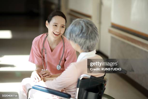 nurse caring for senior woman in wheelchair - medical procedure stock pictures, royalty-free photos & images