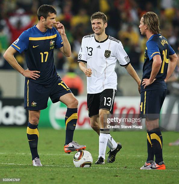 Thomas Mueller of Germany smiles as Nikita Rukavytsya and Brett Holman of Australia restart the match again during the 2010 FIFA World Cup South...