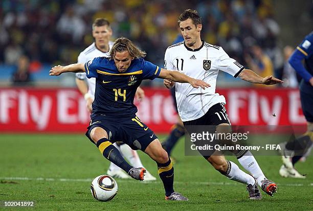 Brett Holman of Australia is challenged by Miroslav Klose of Germany during the 2010 FIFA World Cup South Africa Group D match between Germany and...