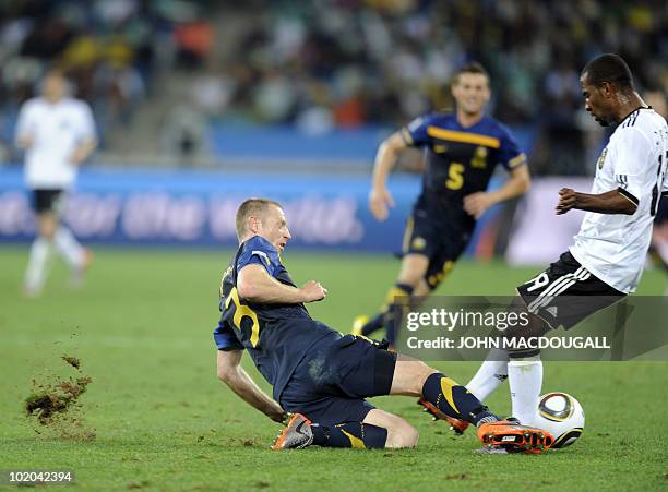 Germany's striker Cacau is challenged by Australia's defender Craig Moore during their Group D first round 2010 World Cup football match on June 13,...