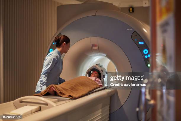 verpleegster meisje kijken tijdens cat-scan examen - cat scan stockfoto's en -beelden