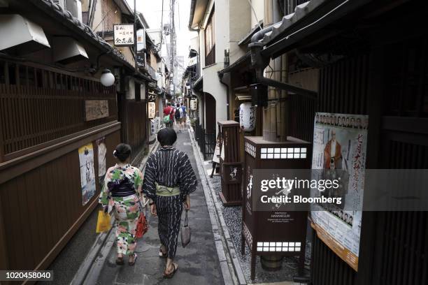 Couple wearing rental kimonos walks through the Pontocho area in Kyoto, Japan, on Wednesday, July 25, 2018. Corporate Japan has a reputation for long...