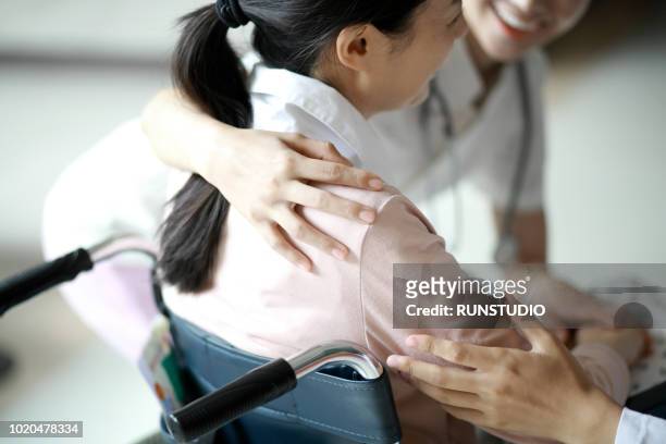 nurse assisting patient in wheelchair - attrezzatura ortopedica foto e immagini stock