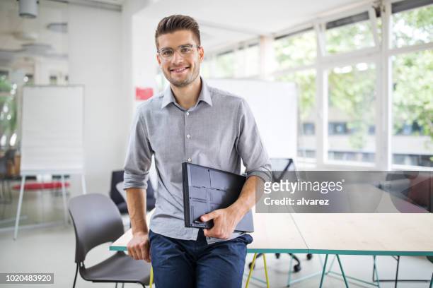 confident businessman standing by conference table - smart casual stock pictures, royalty-free photos & images