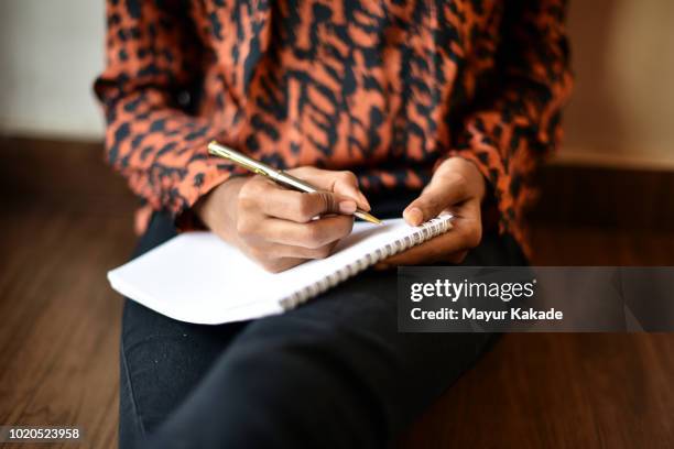 girl writing on notepad - scriptwriter foto e immagini stock