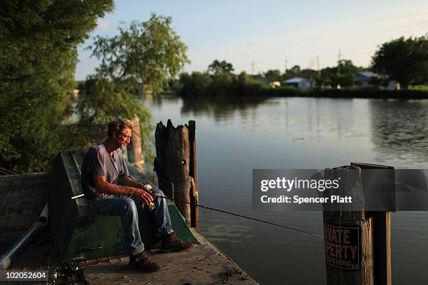 Phillip Boudreaux fishes for catfish along a bayou June 13, 2010 in Lafourche, Louisiana. Commercial fishing, including areas in Lafourche, has been...