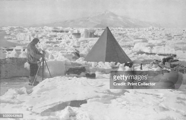 The Lower Koettlitz Glacier' . Camp in pinnacled ice at mouth of Koettlitz Glacier, geologist Raymond Priestley takes a reading from a piece of...