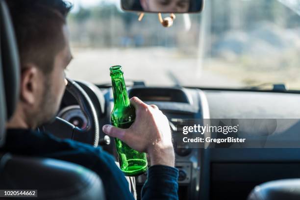 man bier drinken tijdens het rijden van een auto - auto-ongeluk stockfoto's en -beelden