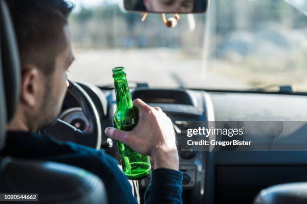 man drinking beer while driving a car - dui imagens e fotografias de stock