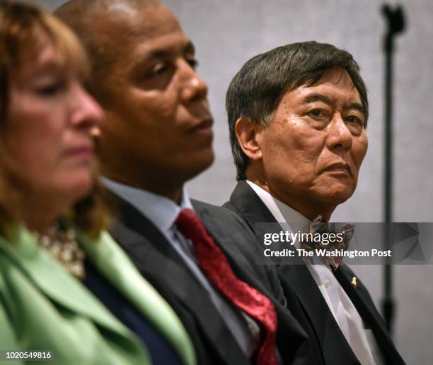 The University of Maryland President Wallace D. Loh, right, and Athletic Director Damon Evans, center, wait to hold a press conference on August 2018...