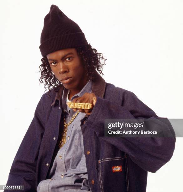 Portrait of American actor and comedian Chris Rock, wearing a denim jacket and a knit cap, along with a large gold ring that spells 'Gusto,' while in...