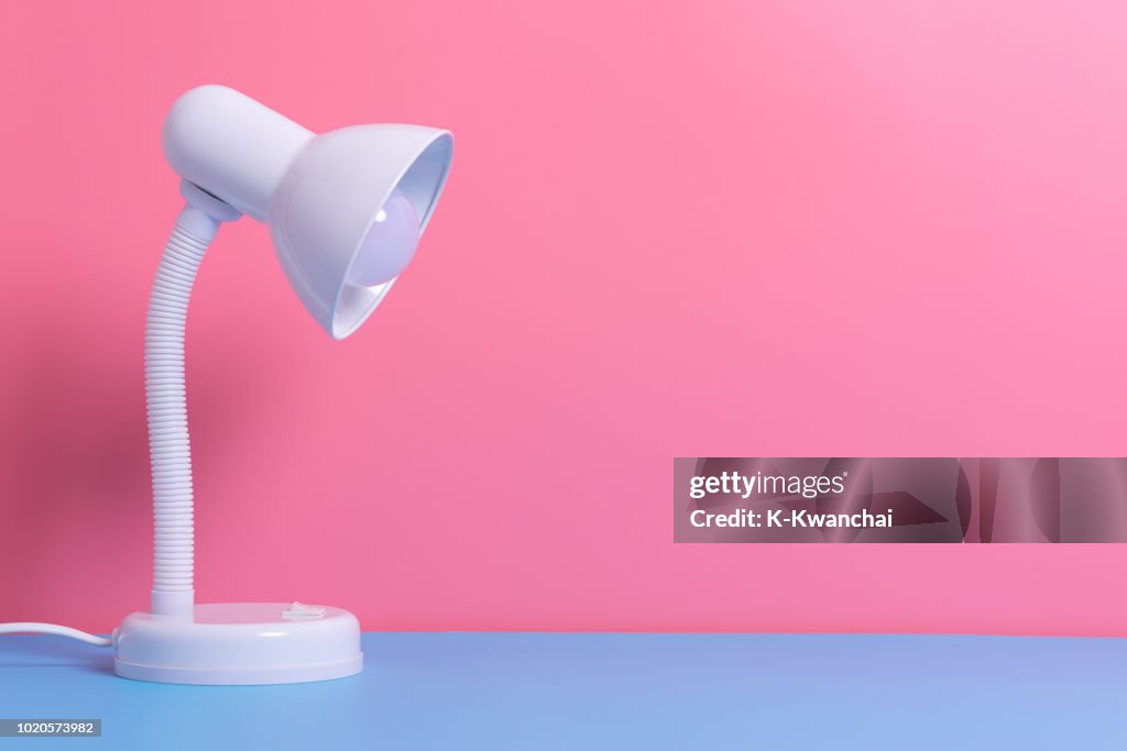 Close-Up Of Electric Lamp On Table Against Wall