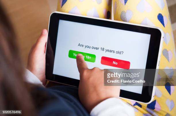 kid using a tablet to gain access to adult content on the internet - interdiction photos et images de collection