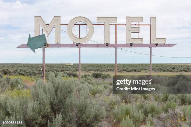 motel sign in field of sage brush, out of context - arrows landscapes stock pictures, royalty-free photos & images