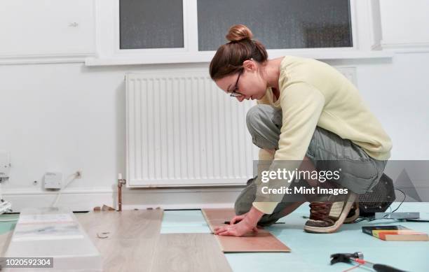 woman fitting new floor boards, house renovation - one woman only kneeling stock pictures, royalty-free photos & images