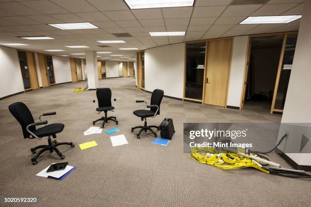 three chairs sitting alone in an open area in an unoccupied office space. - open space office stock-fotos und bilder