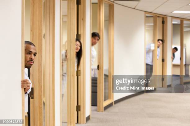 individual business people looking out the doorway of their offices. - nosy stock pictures, royalty-free photos & images