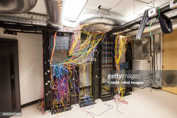 a mess of cat 5 cables in an office server room. - chaos büro stock pictures, royalty-free photos & images