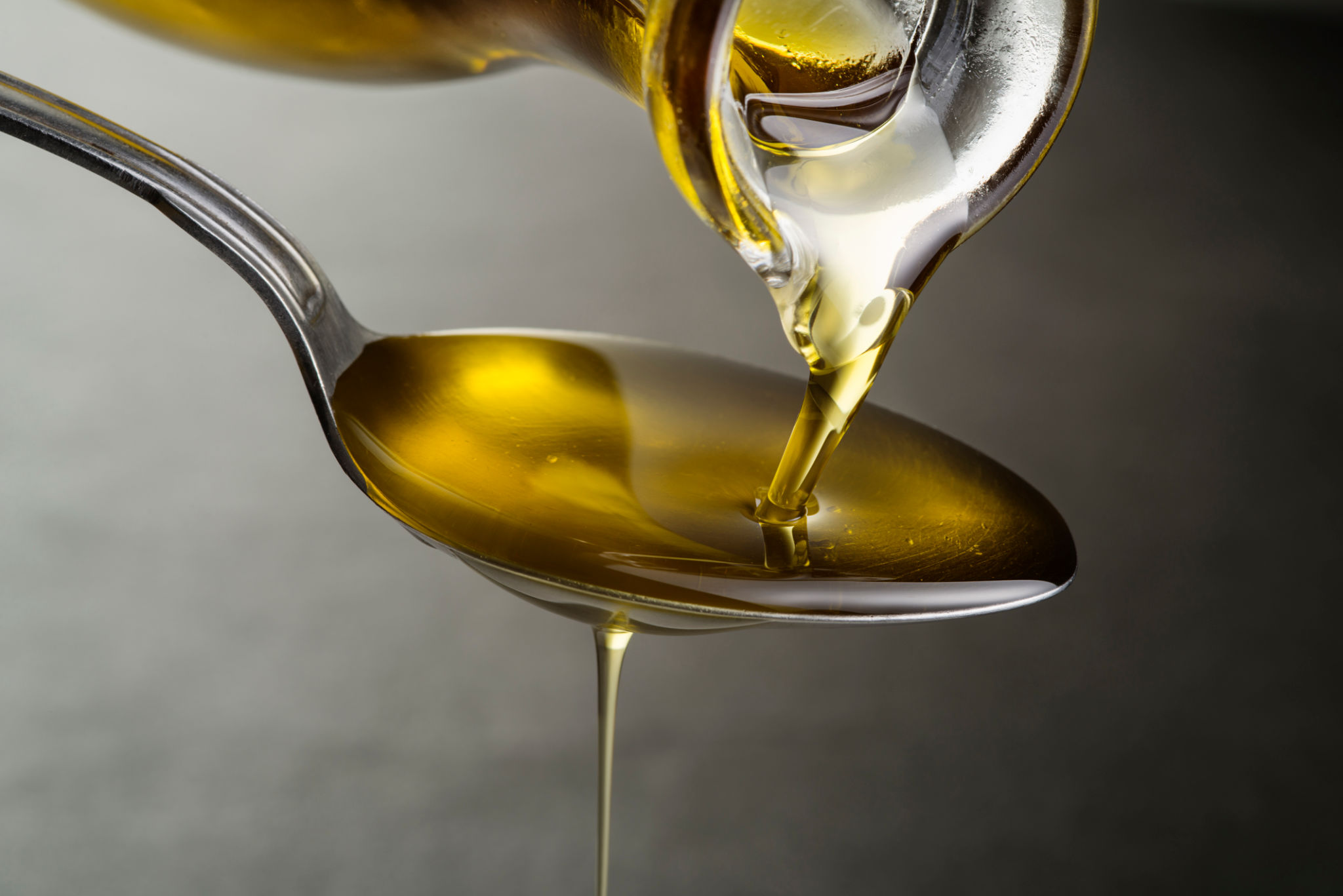 Oil pouring and dripping to the spoon Oil pouring and dripping to the spoon