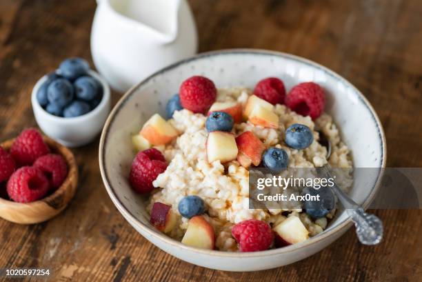 oatmeal porridge with berries and honey on wooden table - calcio sport imagens e fotografias de stock