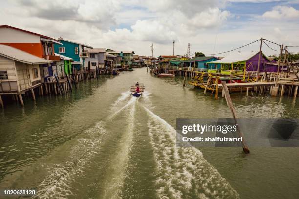 a daily life activity using a boat is a normal view at pulau ketam (crab island). this island is famous for sea food products and restaurants. - asia village river stock pictures, royalty-free photos & images