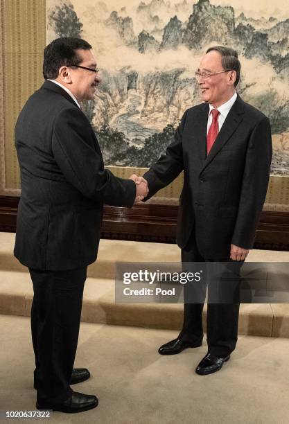 Chinese Vice President Wang Qishan shakes hands with Medardo Gonzalez, a Salvadoran politician, Secretary General of the ruling party of El Salvador,...