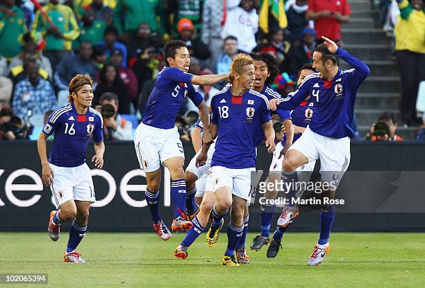Keisuke Honda of Japan celebrates scoring the opening goal with team mates during the 2010 FIFA World Cup South Africa Group E match between Japan...