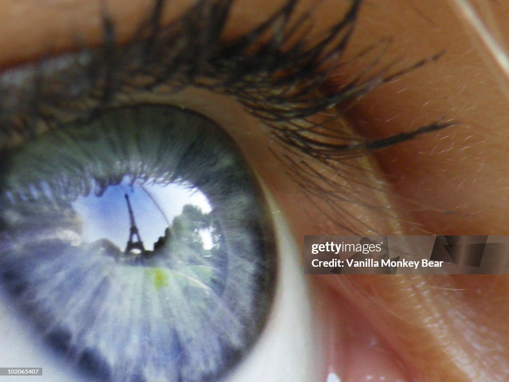 Eiffel Tower reflected in a girl's blue eye