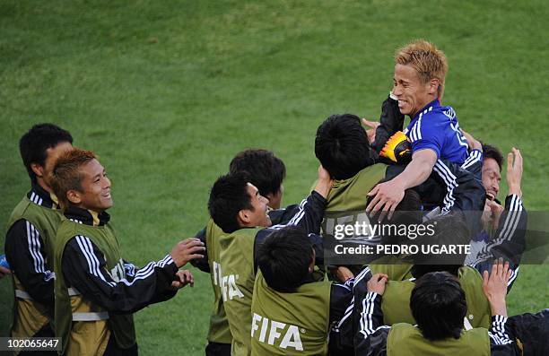 Japan's midfielder Keisuke Honda celebrates with teammates after scoring during their Group E first round 2010 World Cup football match on June 14,...