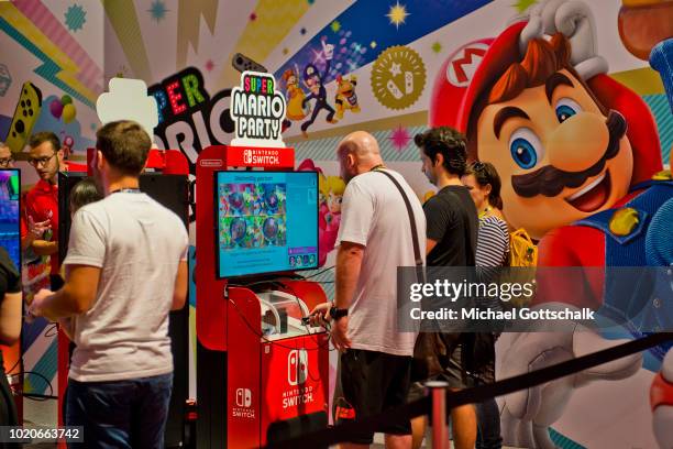 Visitors try video games at Nintendo booth at 2018 gamescom fair press day on August 21, 2018 in Cologne, Germany. Gamescom is Europe's biggest trade...
