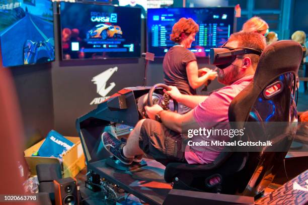 Visitorr tries a car racing video game at 2018 gamescom fair press day on August 21, 2018 in Cologne, Germany. Gamescom is Europe's biggest trade...